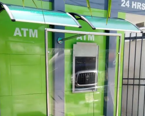 Green ATM kiosk with a glass canopy