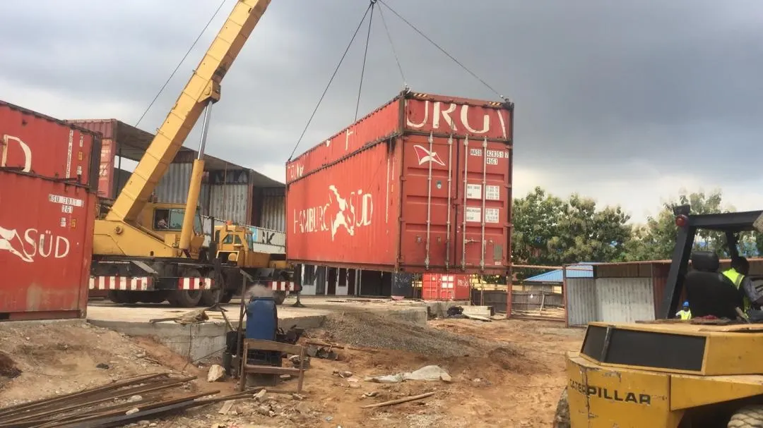 Crane lifting shipping containers on a construction site