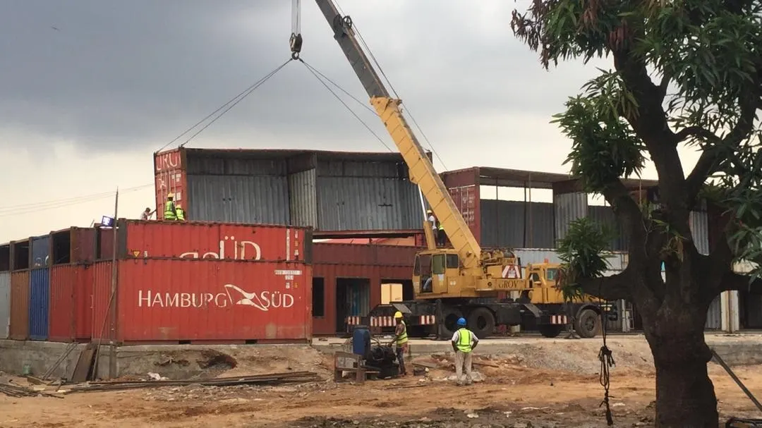 Crane positioning a container module on site