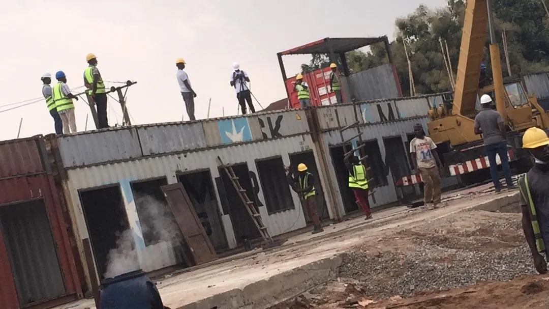 Crew working on top of a stacked container building