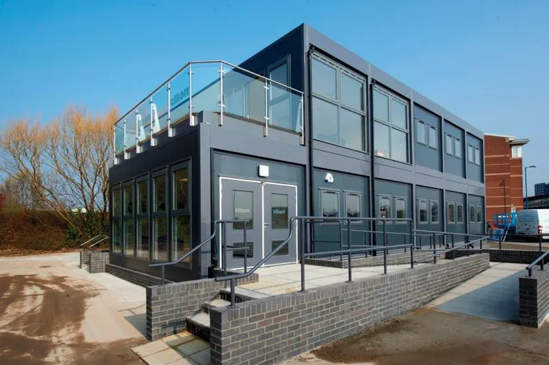 Two-storey modular office with glazed walls and a balcony