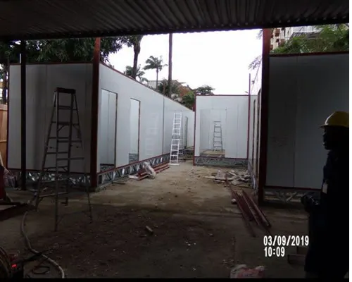 Row of portacabins under construction along a covered walkway