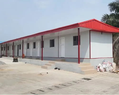 Long portacabin block with a red roof and veranda