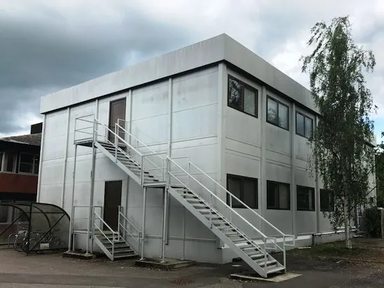 White two-storey portacabin with external metal staircase